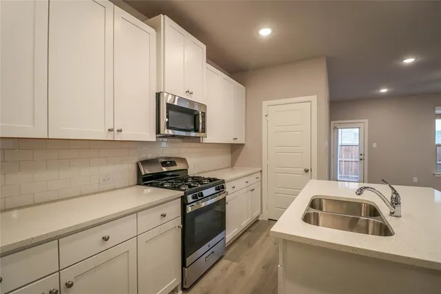 a kitchen that has a sink and a stove top oven