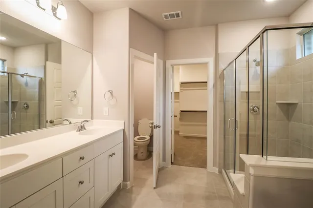 a spacious bathroom with a shower sink and mirror