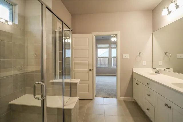 a bathroom with a double vanity sink mirror and shower