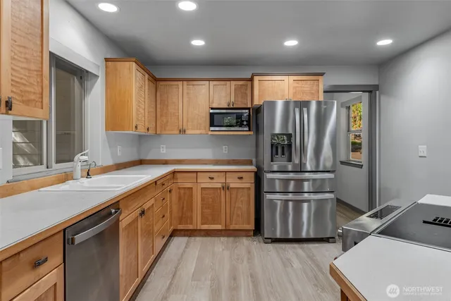 a kitchen with stainless steel appliances granite countertop a refrigerator and a sink