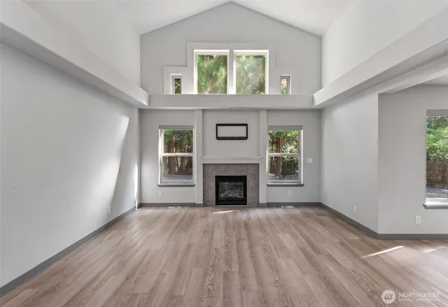 wooden floor fireplace and windows in an empty room