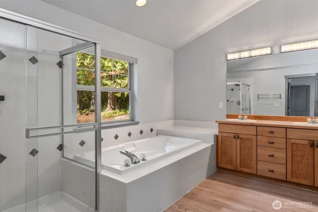 a bath room with a sink mirror and a bathtub
