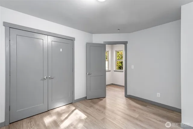 an empty room with windows and closet