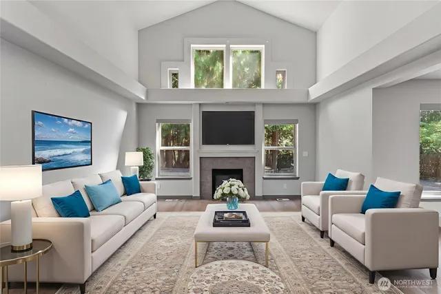 a living room with furniture a fireplace and a large window
