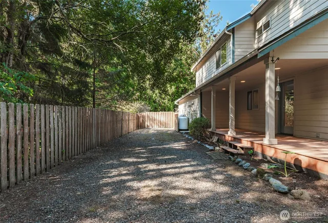 a view of a house with a small yard and wooden fence
