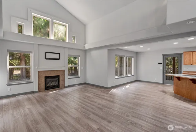 a view of a livingroom with wooden floor and a fireplace