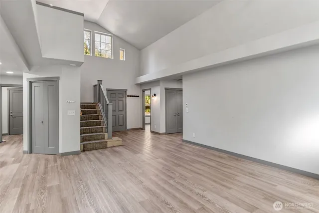 a view of empty room with wooden floor and stairs
