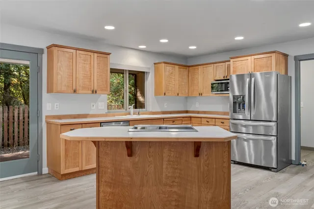 a kitchen with kitchen island a sink appliances and cabinets