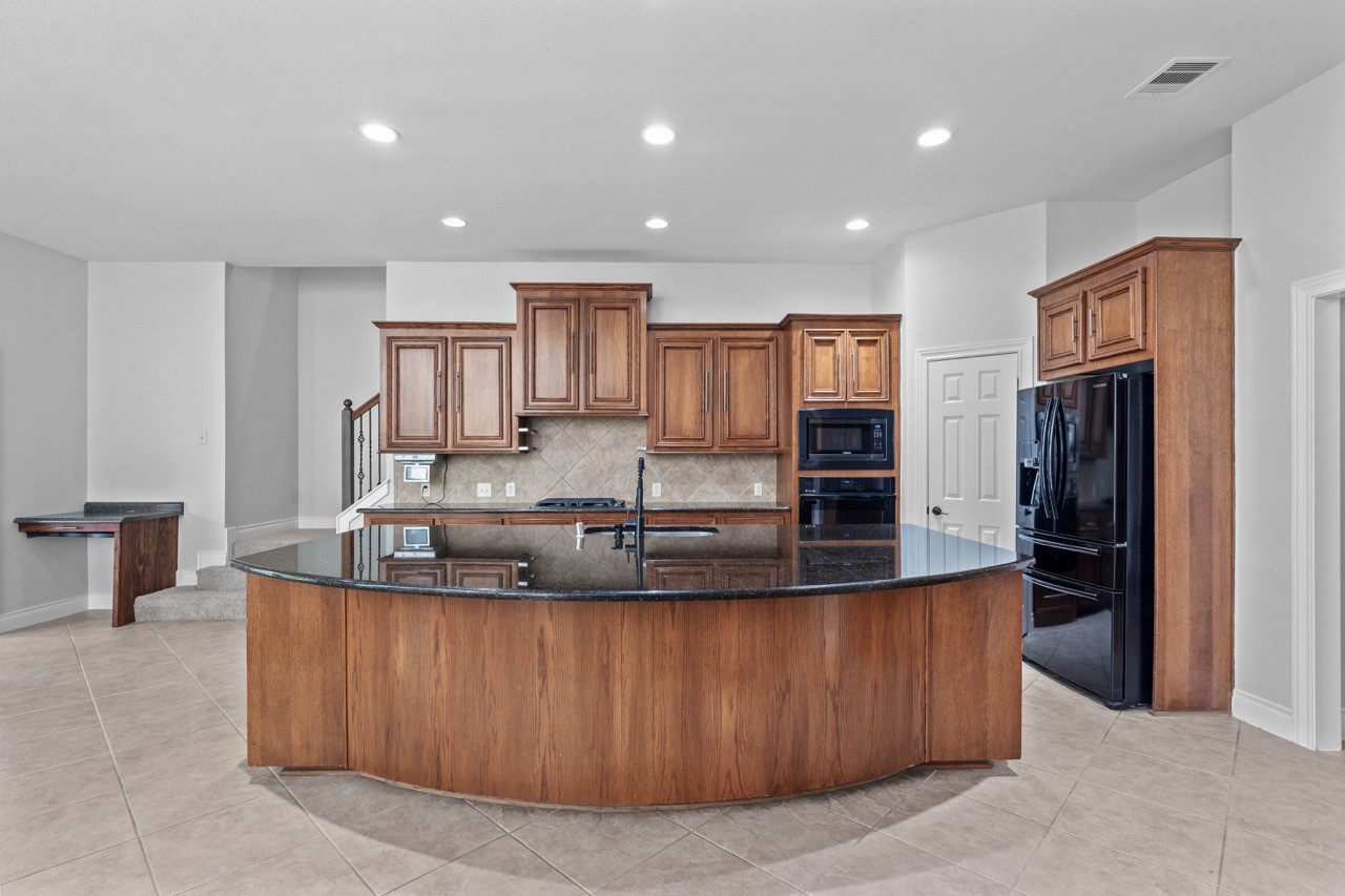 26411 Ridgefield Park Lane Cypress, TX 77433 - Photo 16 of 50 a large kitchen with kitchen island a large counter top stainless steel appliances and cabinets