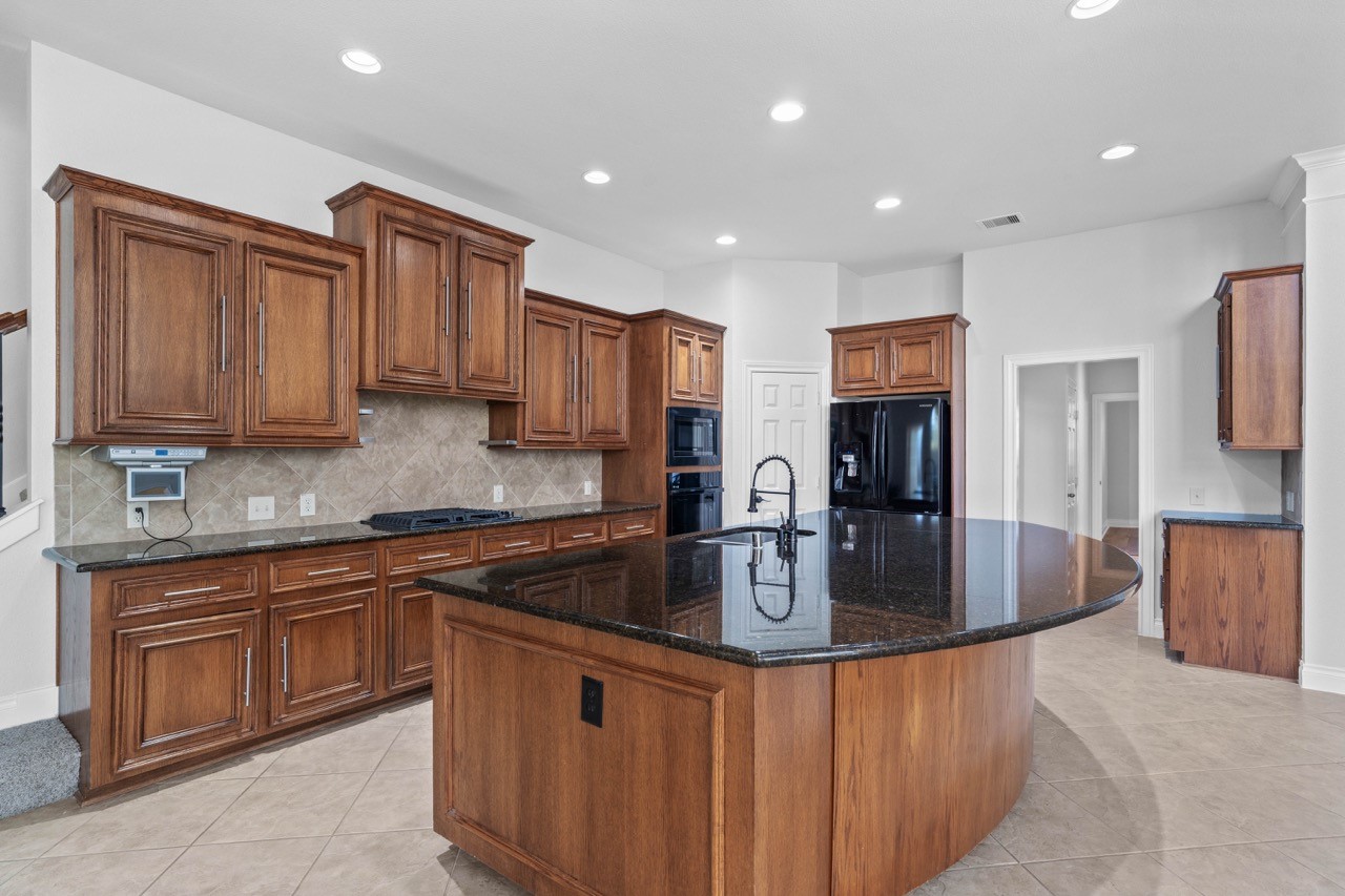 26411 Ridgefield Park Lane Cypress, TX 77433 - Photo 18 of 50 a kitchen with stainless steel appliances granite countertop a sink a stove and a refrigerator
