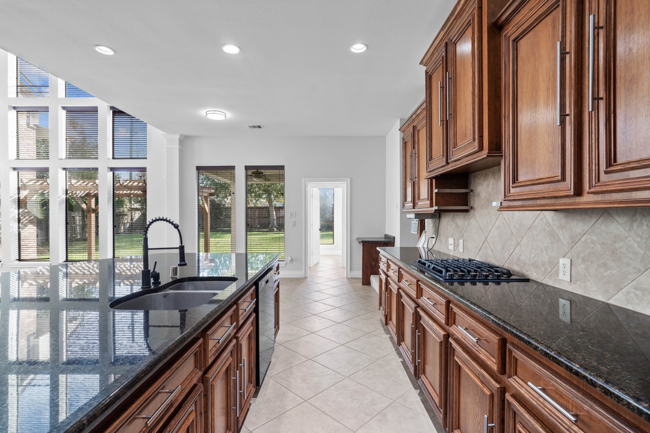 26411 Ridgefield Park Lane Cypress, TX 77433 - Photo 21 of 50 a kitchen with granite countertop a stove and a sink