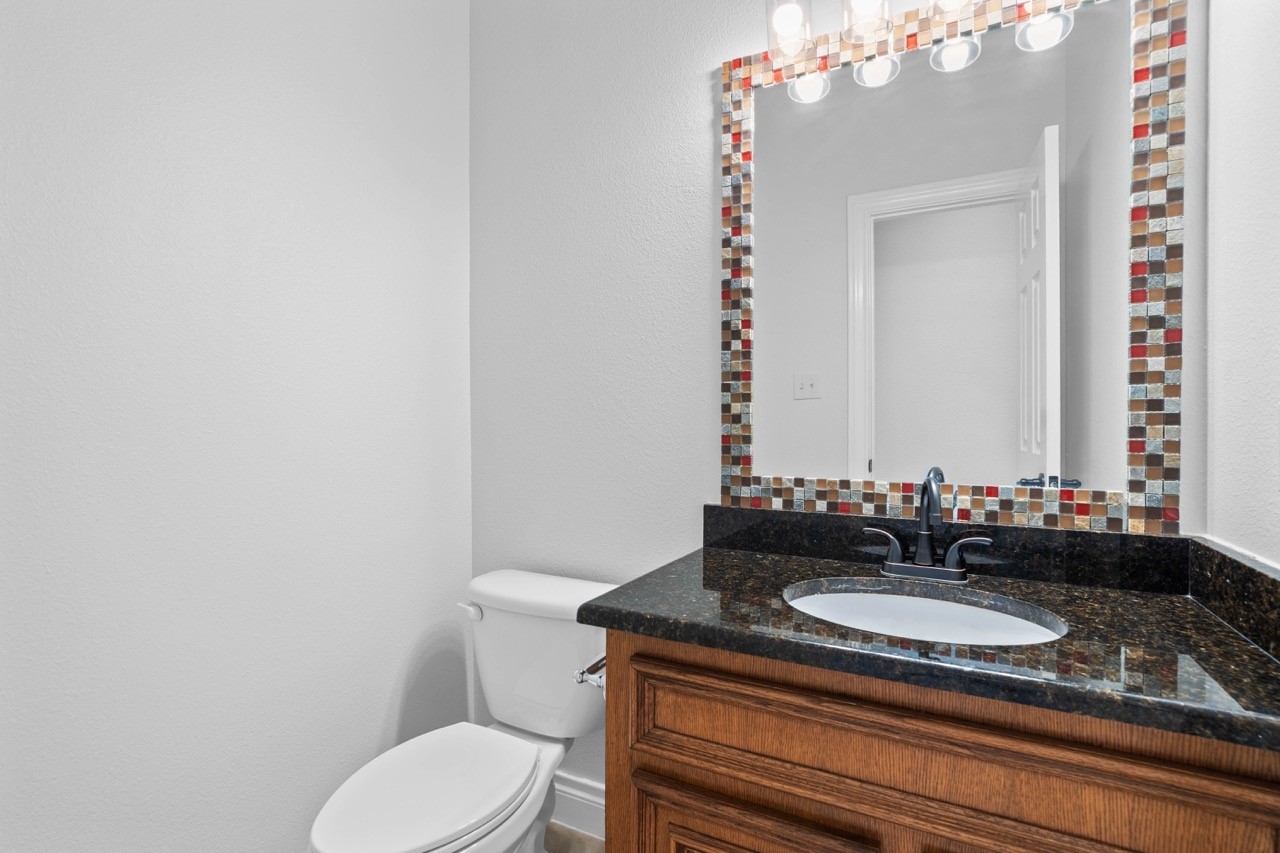 26411 Ridgefield Park Lane Cypress, TX 77433 - Photo 24 of 50 a bathroom with a granite countertop sink vanity mirror and toilet
