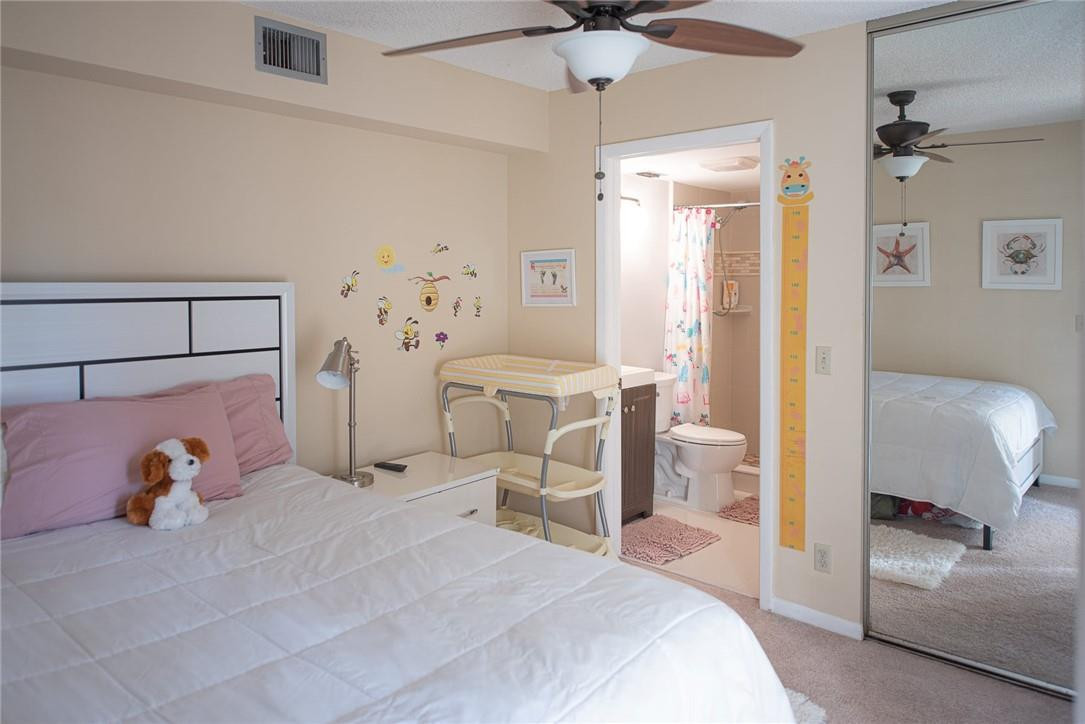 8116 Thames Boulevard, Unit A Boca Raton, FL 33433 - Photo 13 of 27 a bedroom with a bed and a chandelier