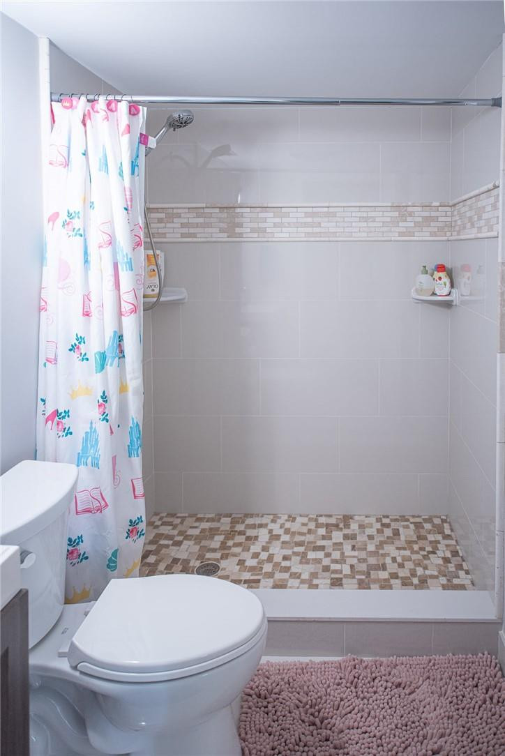 8116 Thames Boulevard, Unit A Boca Raton, FL 33433 - Photo 14 of 27 a white toilet sitting next to a shower curtain