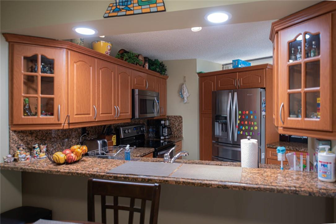 8116 Thames Boulevard, Unit A Boca Raton, FL 33433 - Photo 5 of 27 a kitchen with stainless steel appliances granite countertop a sink and a refrigerator