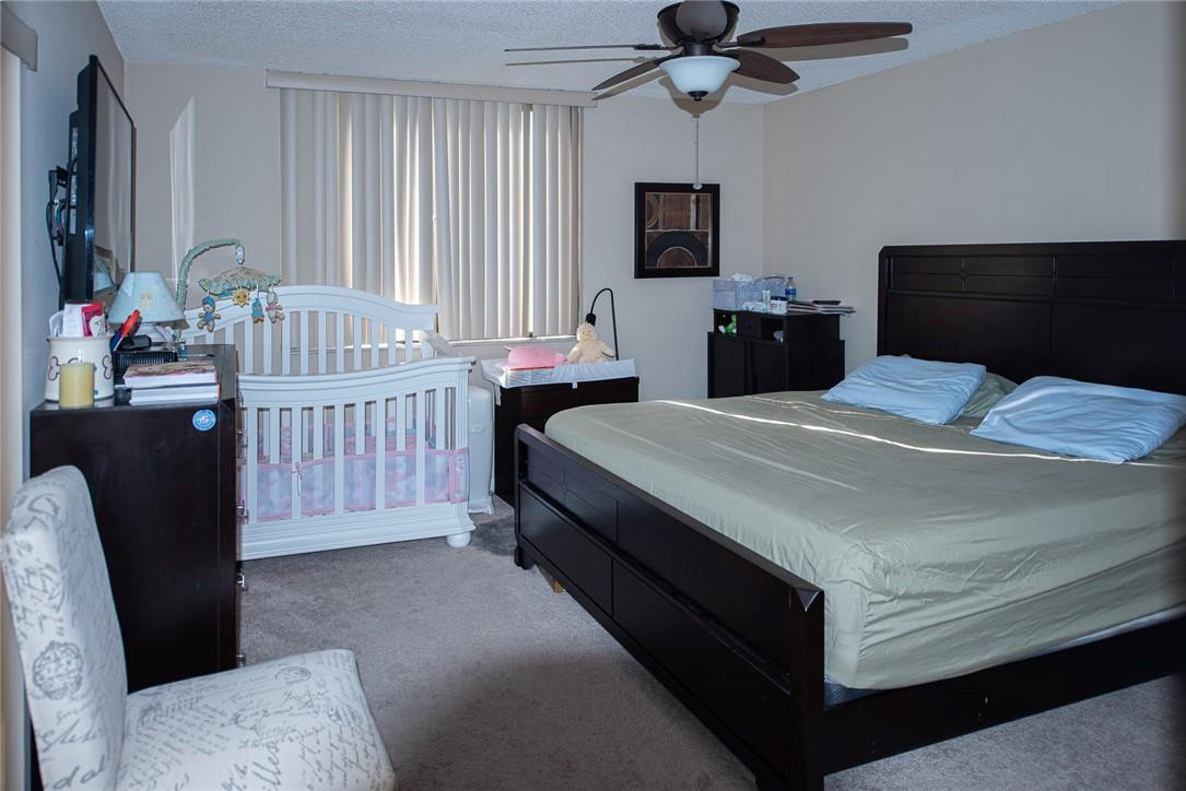 8116 Thames Boulevard, Unit A Boca Raton, FL 33433 - Photo 9 of 27 a bedroom with a bed and a television