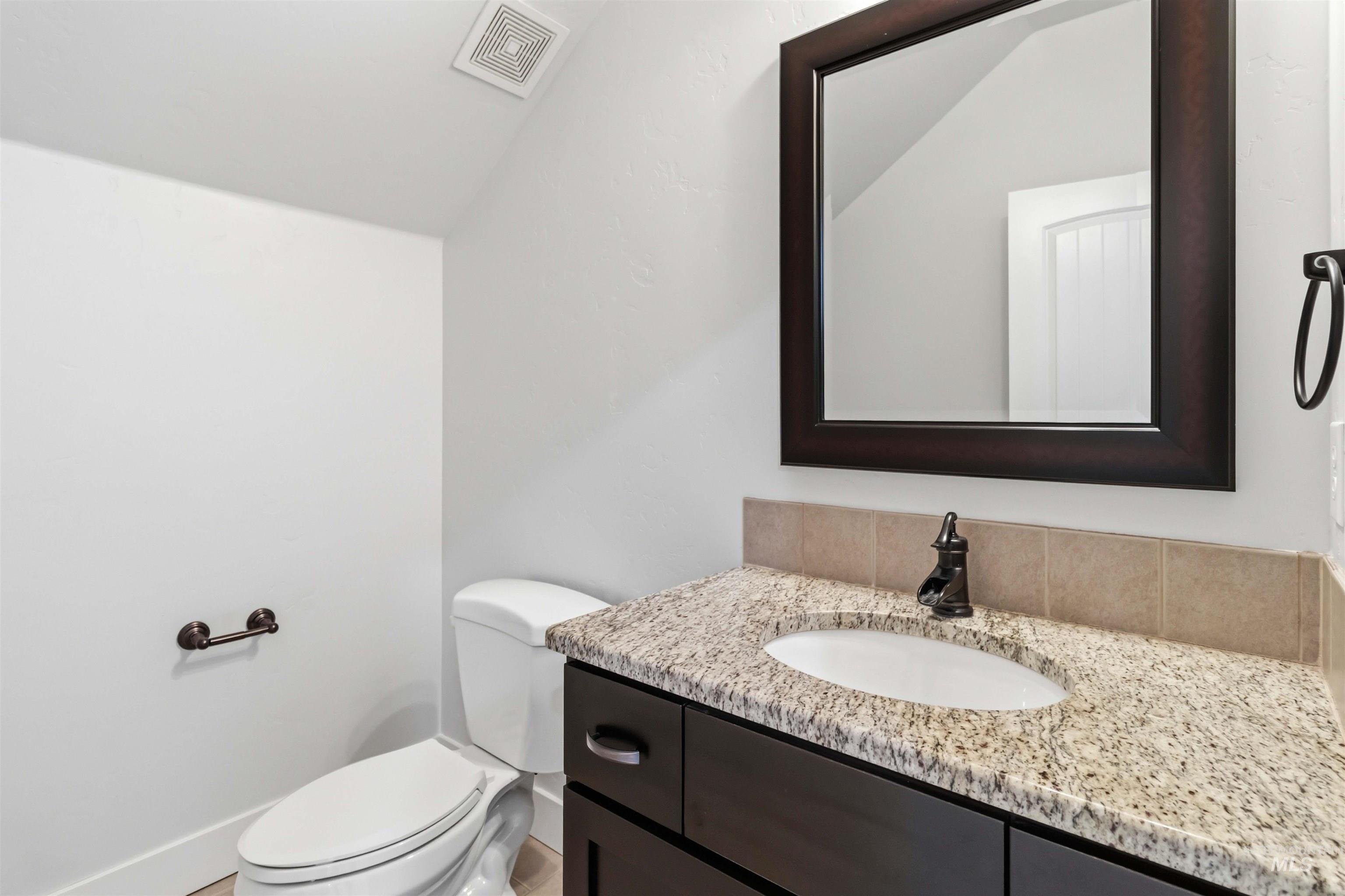 3218 North Cherry Laurel Way Star, ID 83669 - Photo 41 of 50 Bathroom vanity featuring a granite countertop, undermount sink, and dark wood cabinetry