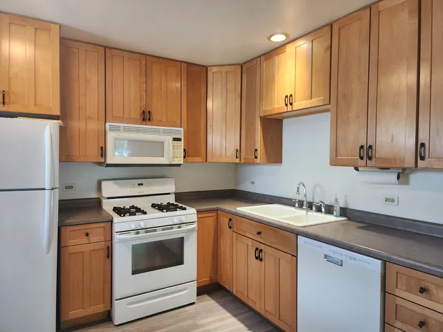 a kitchen with granite countertop cabinets stainless steel appliances and sink