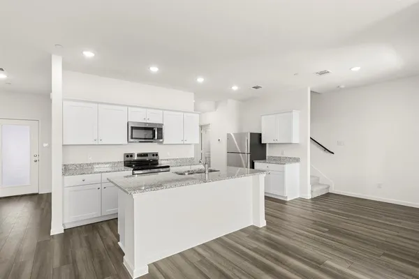 a kitchen with granite countertop white cabinets and sink