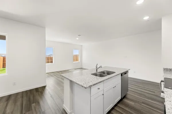 a kitchen with a sink a microwave a refrigerator and cabinets