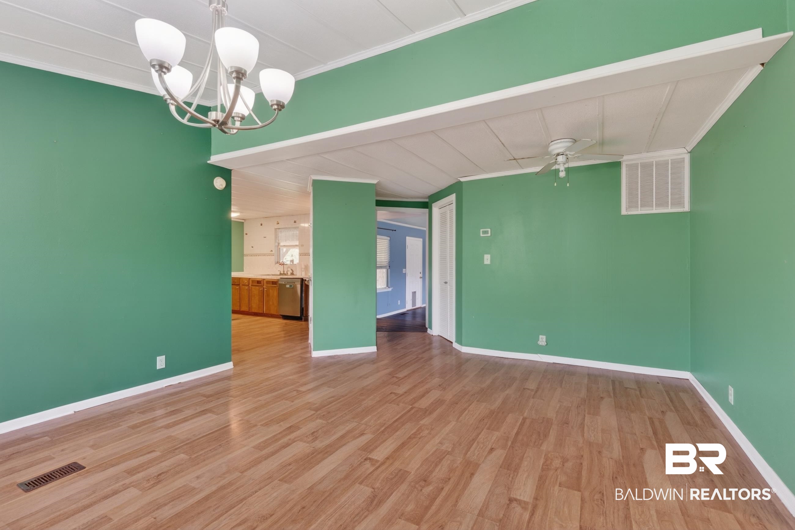 24903 Patterson Road Robertsdale, AL 36567 - Photo 27 of 57 Spacious interior room featuring wood-finish flooring, a contemporary chandelier, white baseboards, and a ceiling fan
