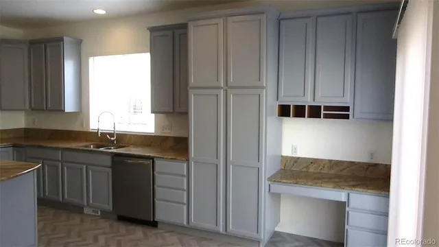 a kitchen with granite countertop a sink stove and refrigerator
