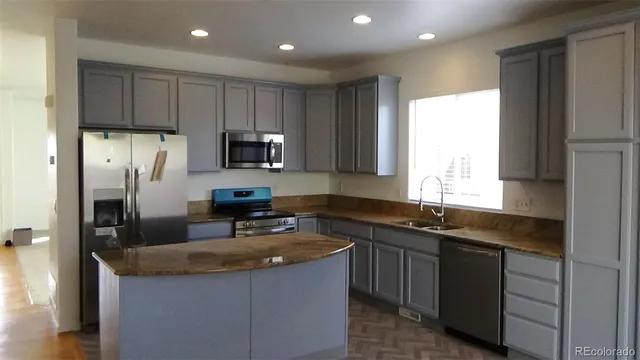 a kitchen with stainless steel appliances granite countertop a sink a stove and a refrigerator