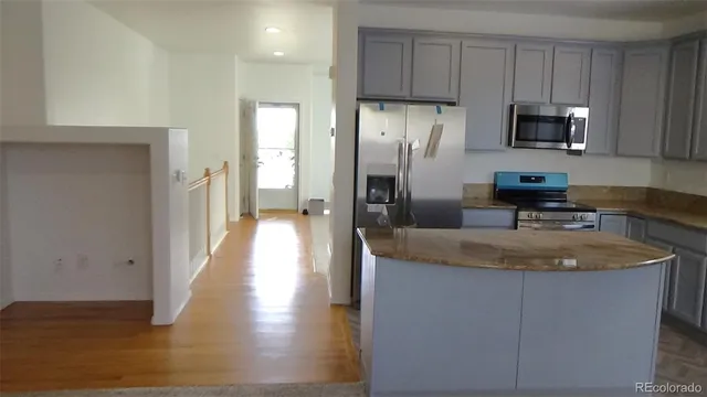 a kitchen with granite countertop a stove and a refrigerator