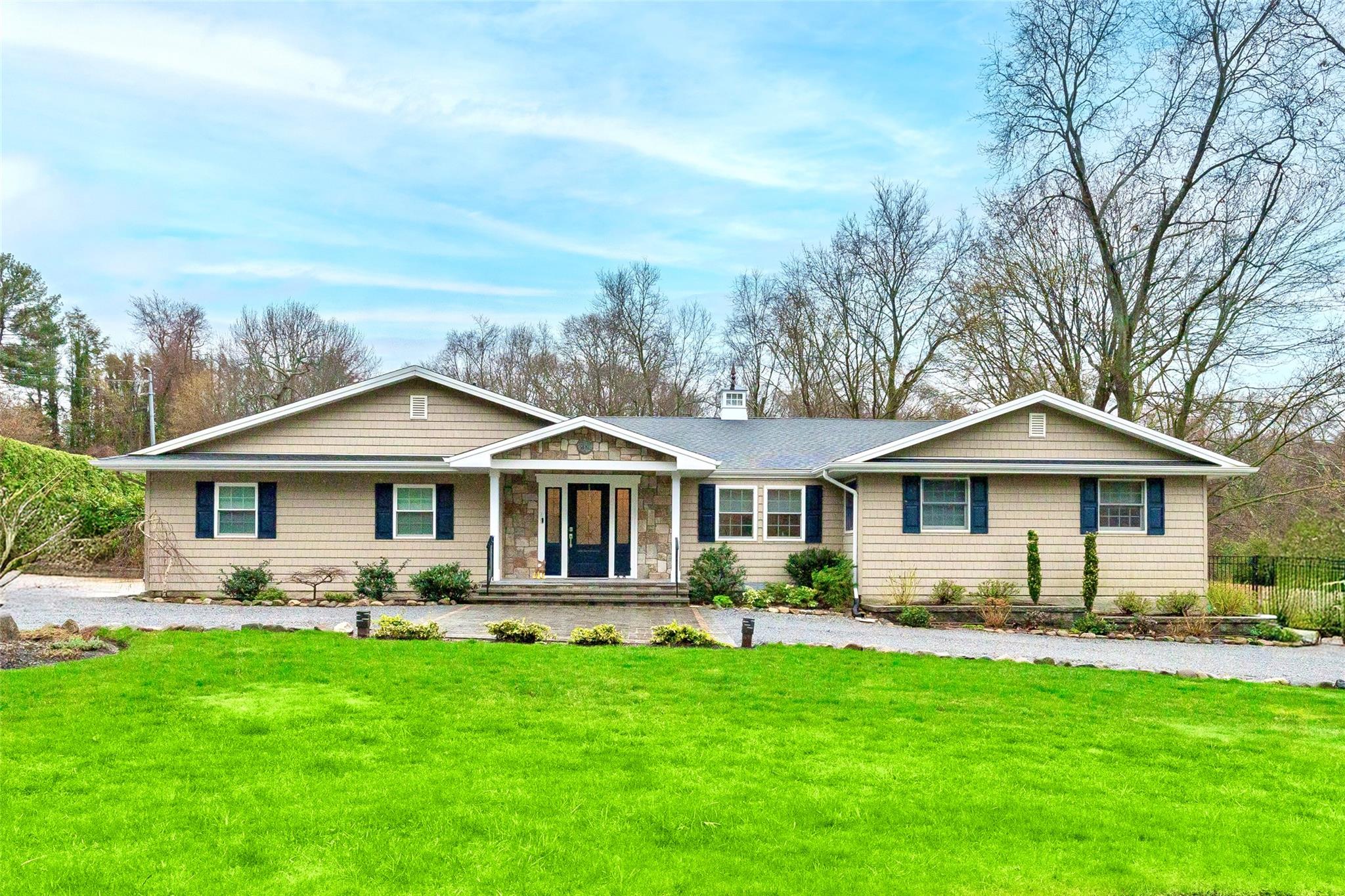 Single story home with a chimney, a shingled roof, and a front lawn