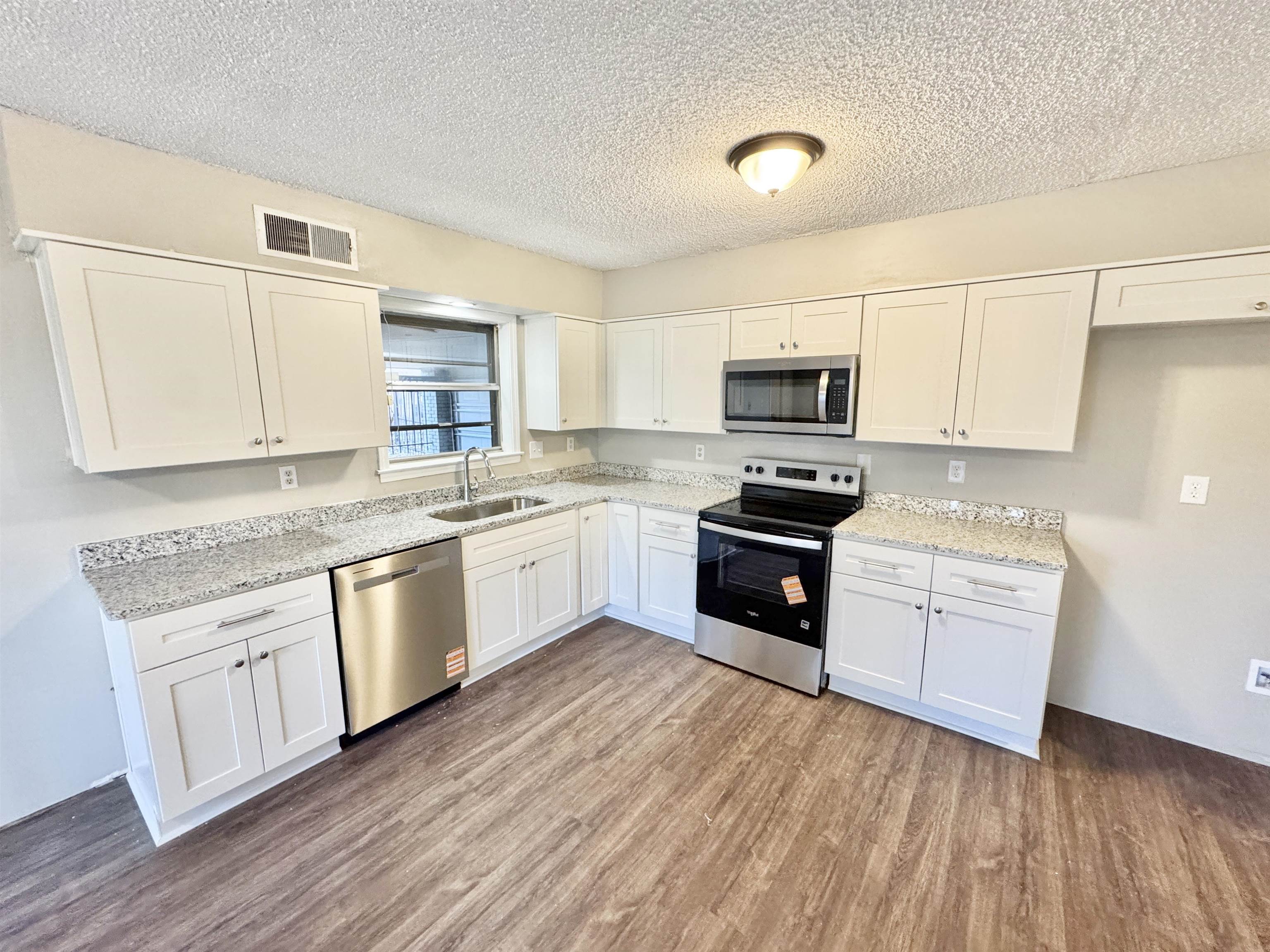 3836 Birchleaf Road Memphis, TN 38116 - Photo 14 of 40 Kitchen with stainless steel appliances, white cabinetry, and a textured ceiling