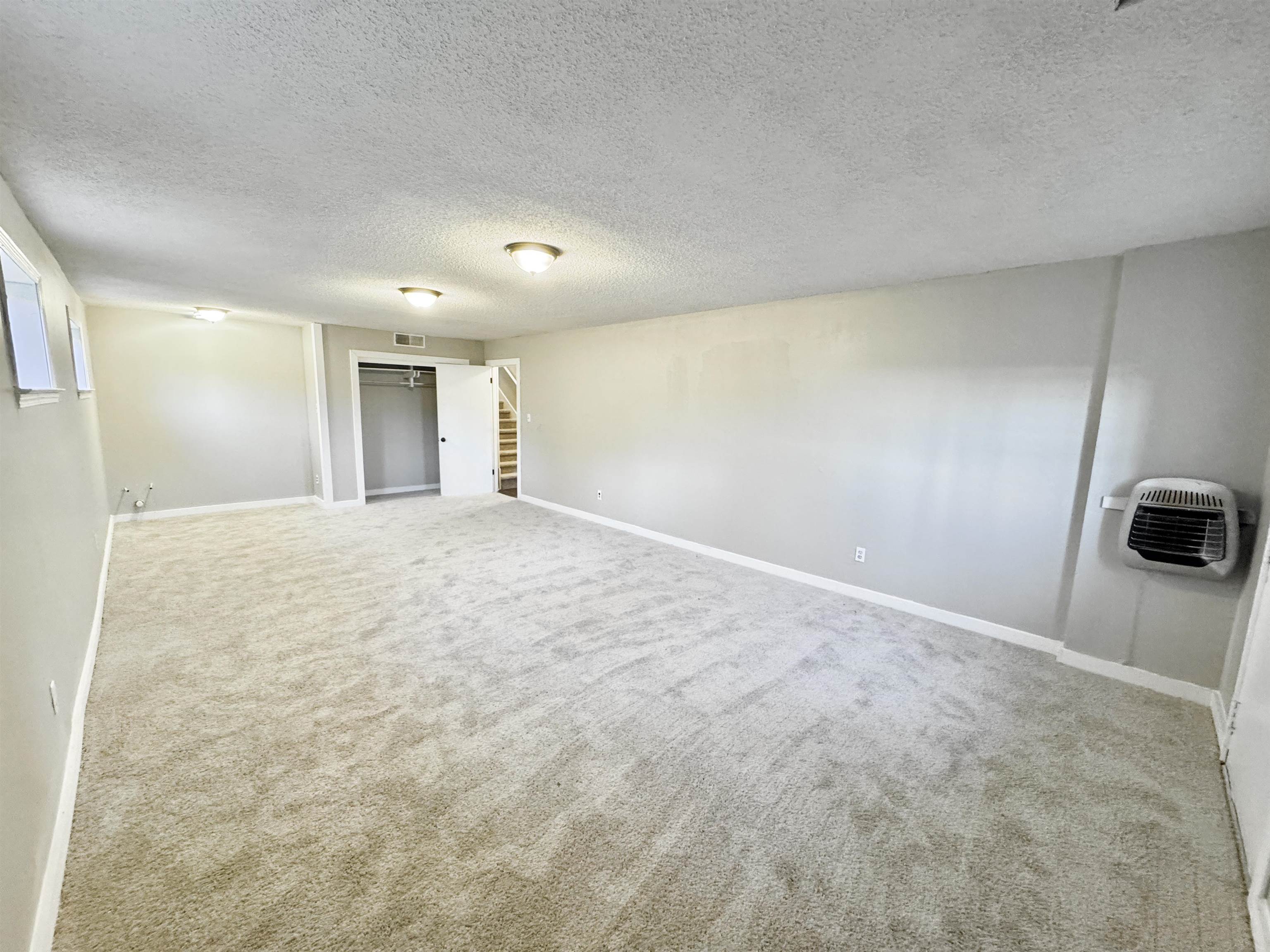3836 Birchleaf Road Memphis, TN 38116 - Photo 23 of 40 Carpeted empty room with a textured ceiling, heating unit, and stairway