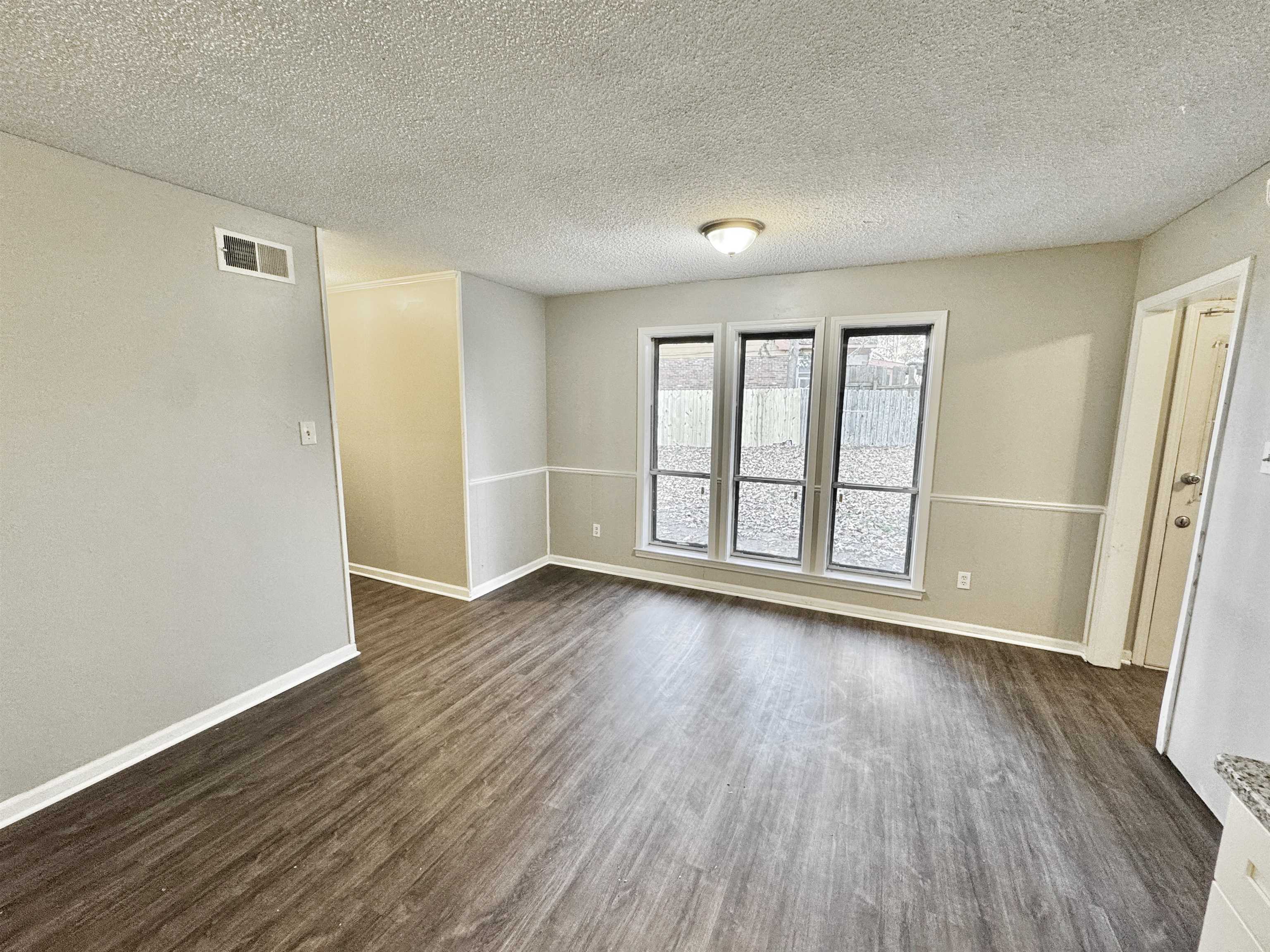 3836 Birchleaf Road Memphis, TN 38116 - Photo 6 of 40 Empty room featuring a textured ceiling and dark wood-type flooring