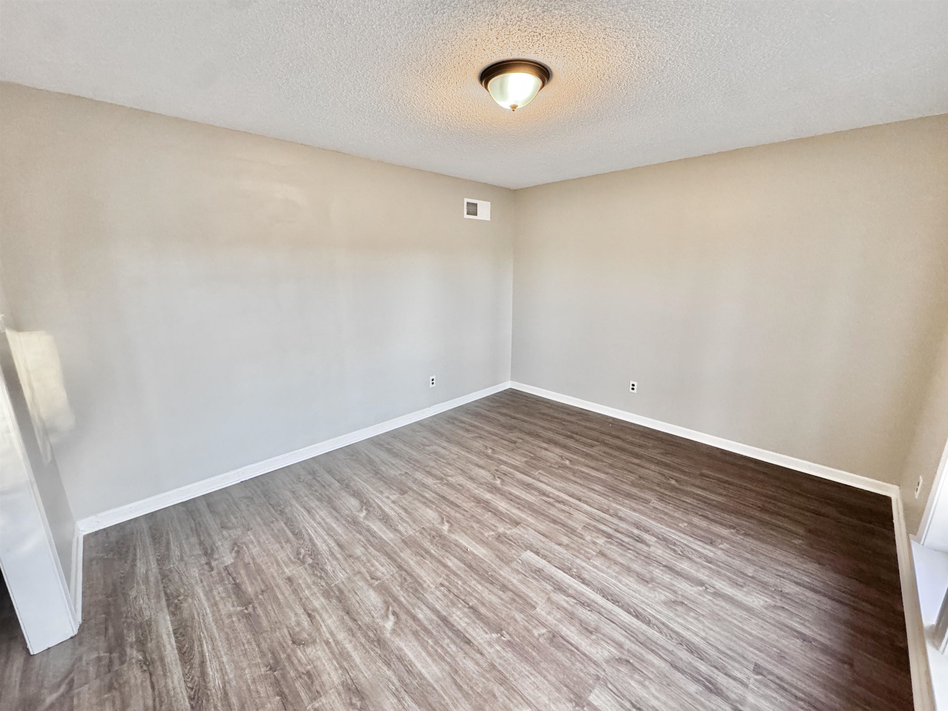 3836 Birchleaf Road Memphis, TN 38116 - Photo 10 of 40 Empty room featuring a textured ceiling and wood finished floors