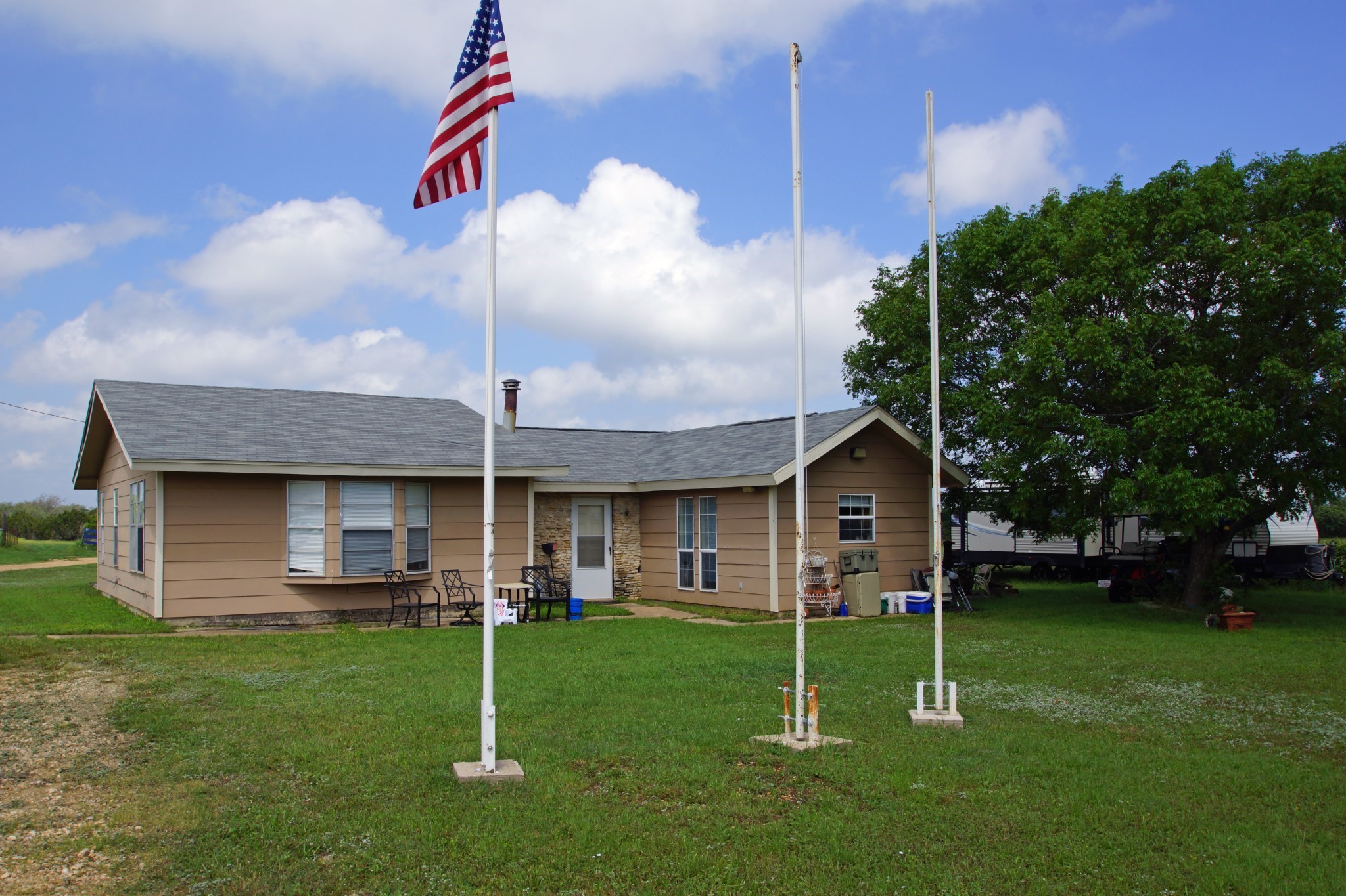 244 Apache Springs Road Briggs, TX 78608 - Photo 2 of 25 a view of a house with a yard fire pit and a large tree