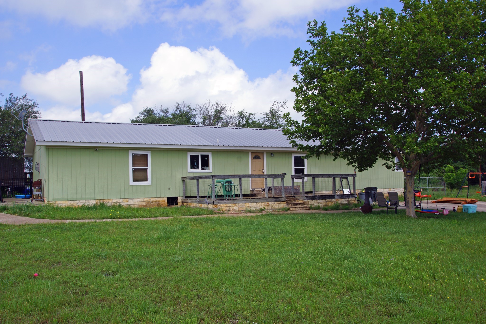 244 Apache Springs Road Briggs, TX 78608 - Photo 7 of 25 a front view of a house with a garden and trees