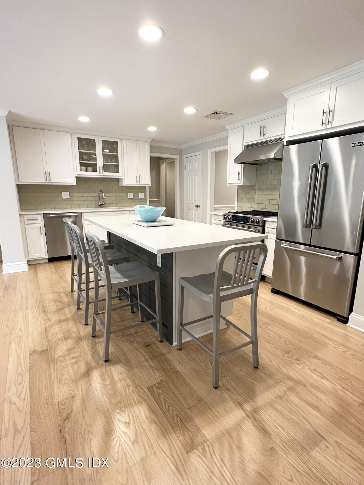 28 Old Orchard Road Riverside, CT 06878 - Photo 3 of 11 a kitchen with stainless steel appliances granite countertop a dining table chairs refrigerator and sink