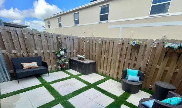 a living room with patio furniture and a wooden floor
