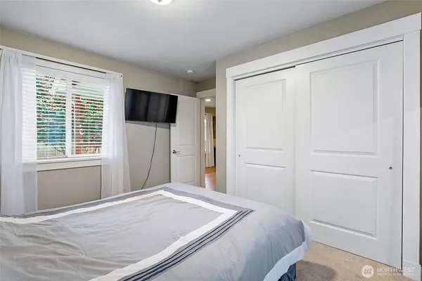 a bedroom with a bed and a flat screen tv