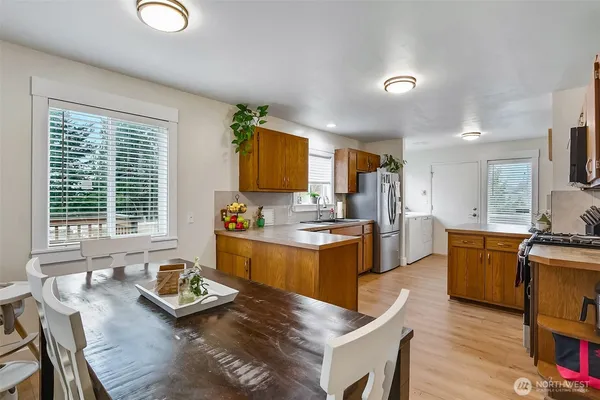 a large kitchen with granite countertop a large window and white cabinets