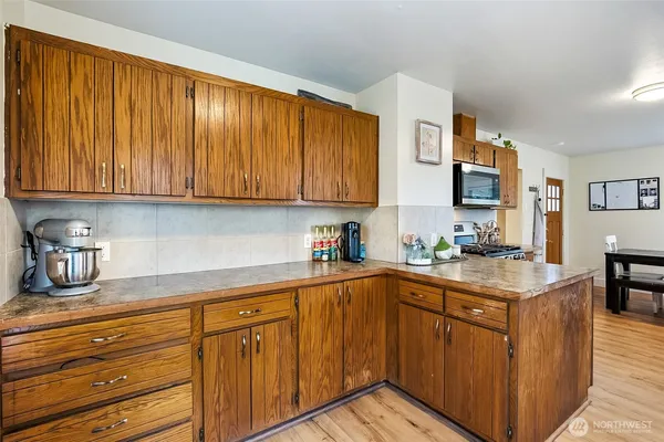 a kitchen with stainless steel appliances granite countertop a sink dishwasher stove and cabinets with wooden floor