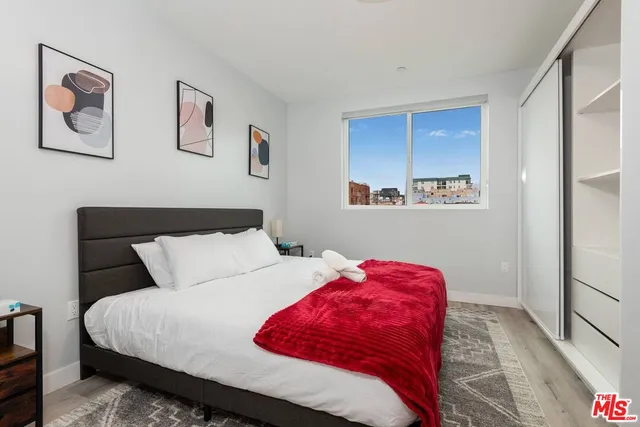 a bedroom with a bed and a painting on the wall