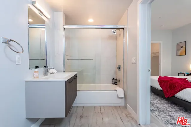 a bathroom with a tub sink and mirror