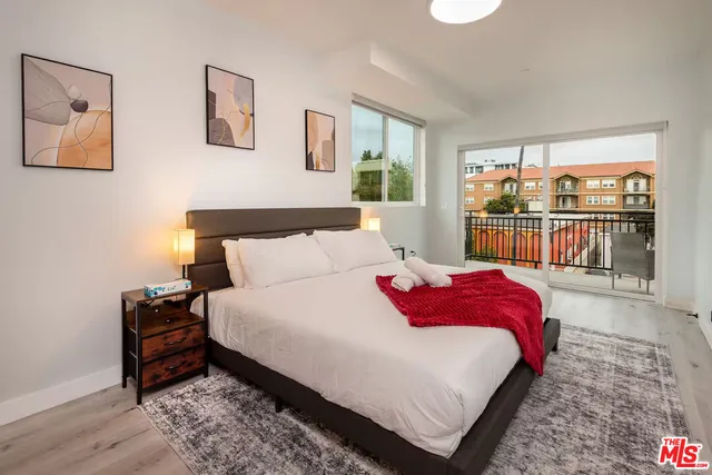 a bedroom with bed and a large window