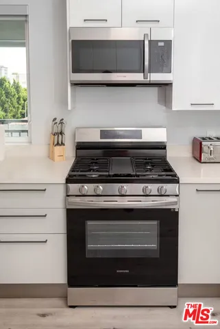 a stove top oven sitting inside of a kitchen