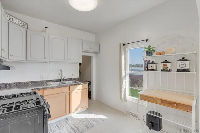 a kitchen with stainless steel appliances granite countertop a sink and a stove