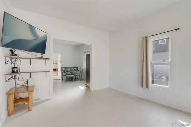 a view of empty room with workspace and a flat screen tv