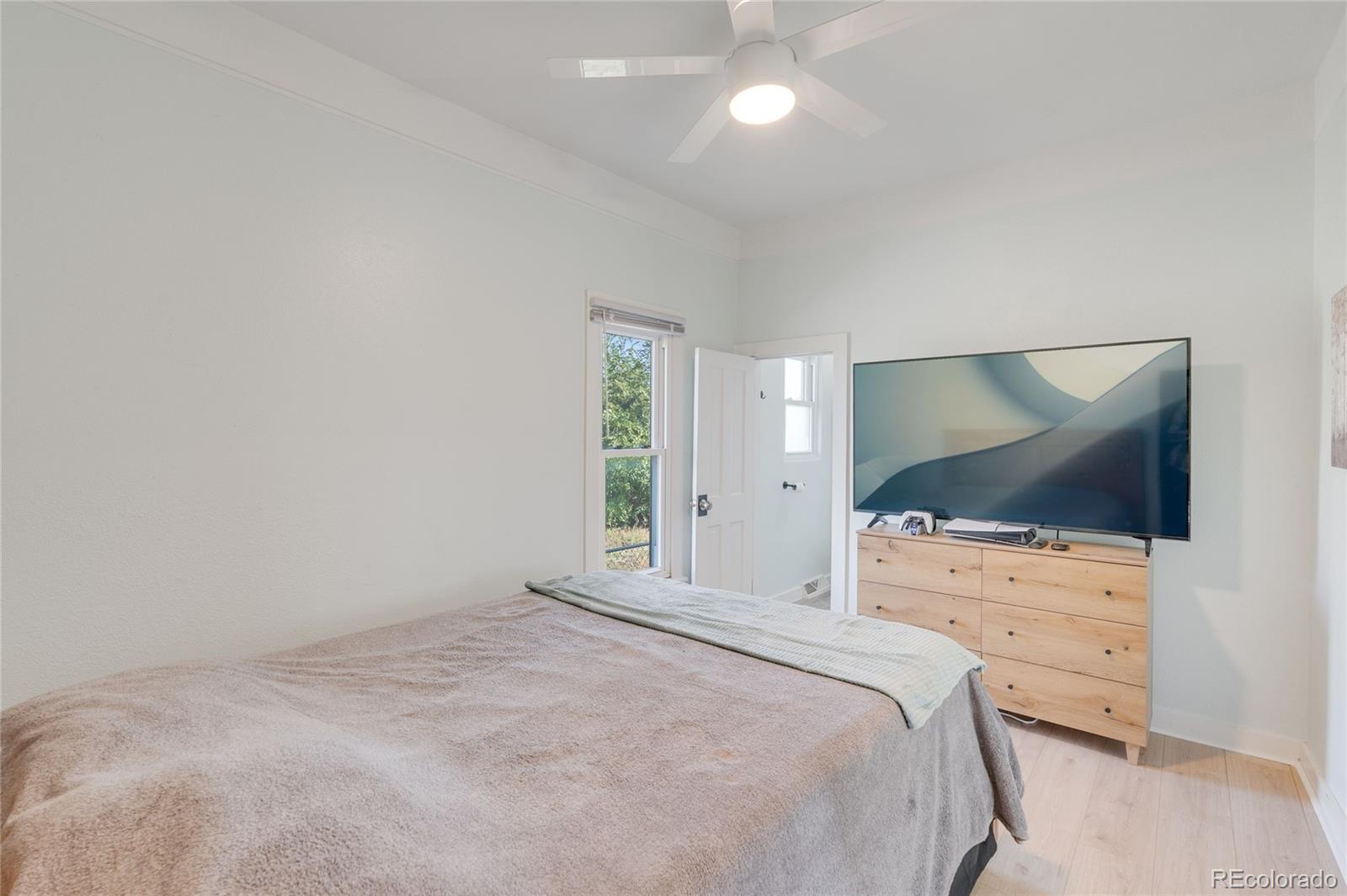 1984 Caroline Avenue Fort Lupton, CO 80621 - Photo 20 of 33 a bedroom with a bed and a flat tv screen on dresser