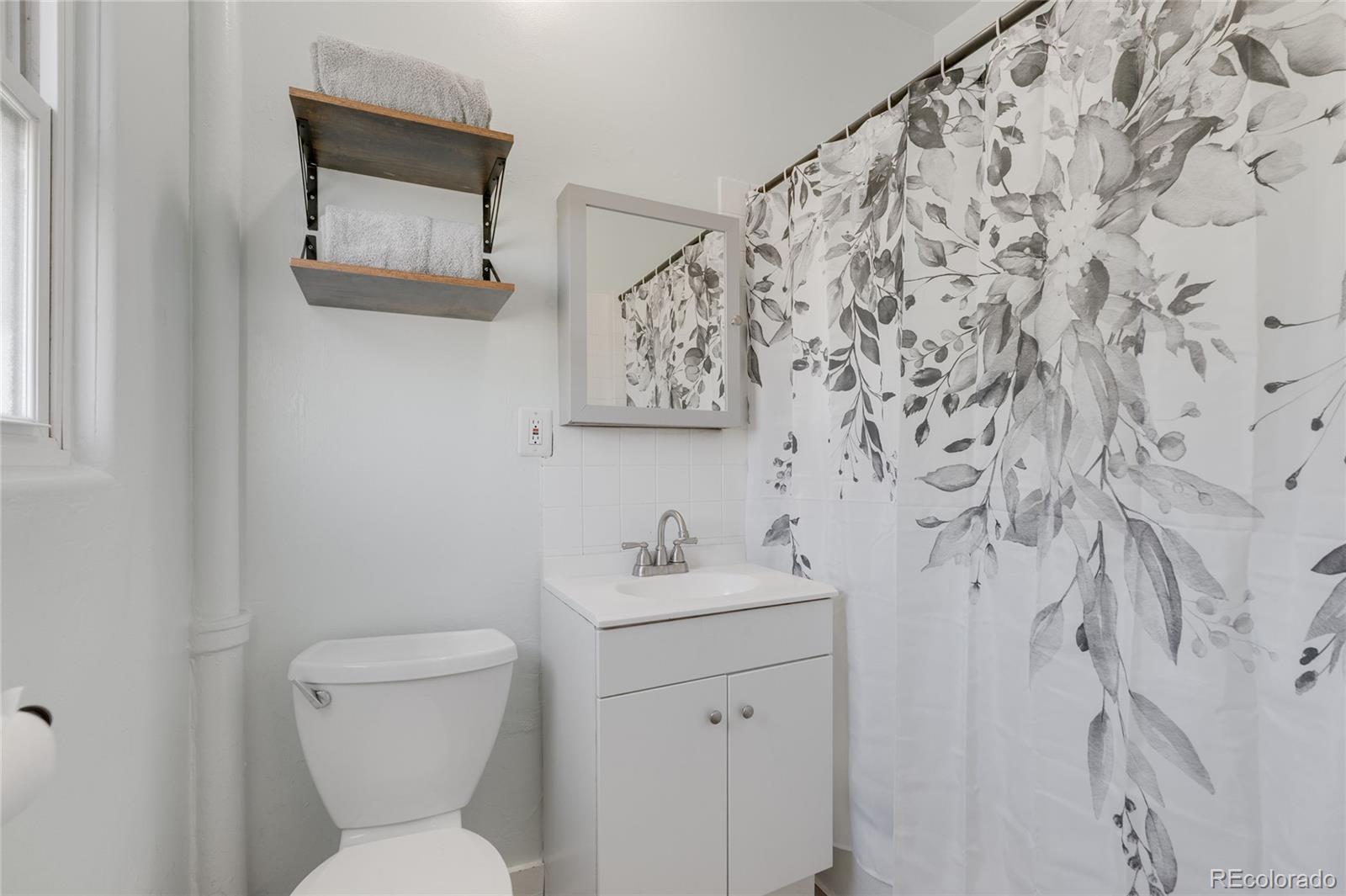 1984 Caroline Avenue Fort Lupton, CO 80621 - Photo 21 of 33 a bathroom with a toilet sink and mirror