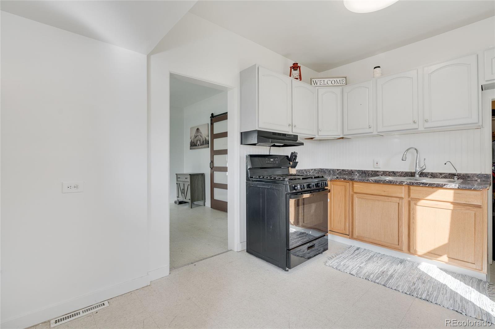 1984 Caroline Avenue Fort Lupton, CO 80621 - Photo 22 of 33 a kitchen with stainless steel appliances granite countertop a stove a sink and a refrigerator