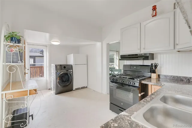 a kitchen with granite countertop a stove and a refrigerator
